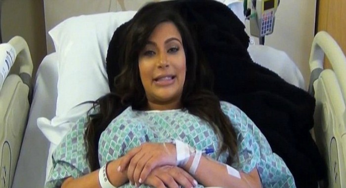 mujer sonriendo en cama de hospital 